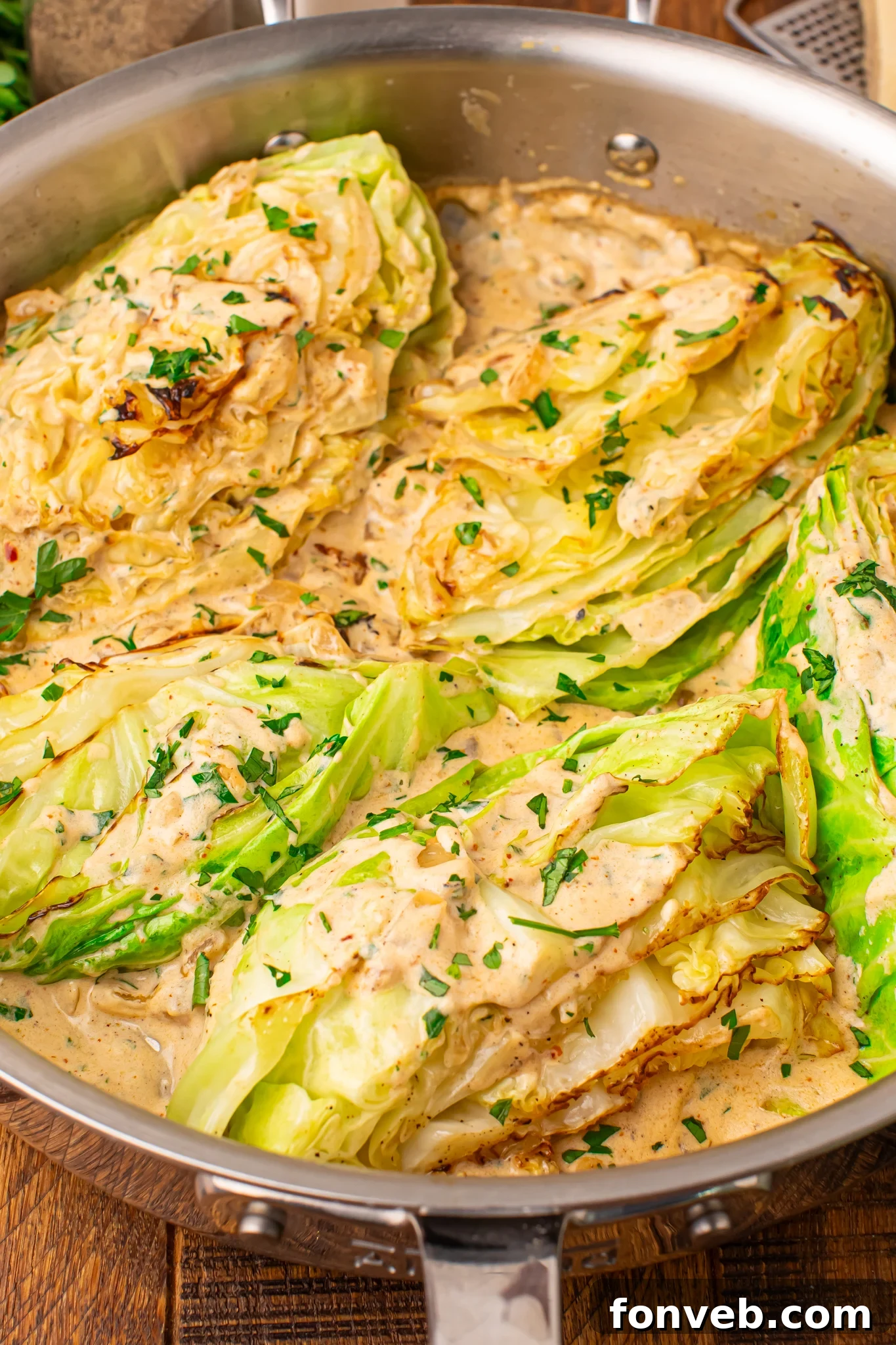 Keto Creamy Garlic Parmesan Cabbage Skillet 21 Creamy Garlic Parmesan Cabbage wedges in a skillet topped with cream sauce