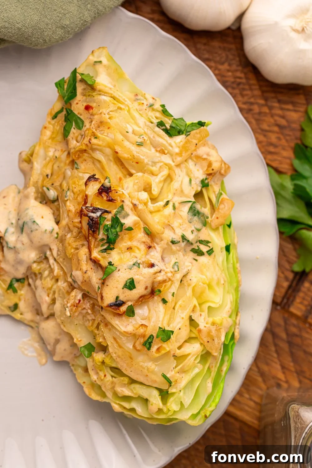 Keto Creamy Garlic Parmesan Cabbage Skillet 4 Single wedge of Creamy Garlic Parmesan Cabbage on a plate, topped with rich cream sauce