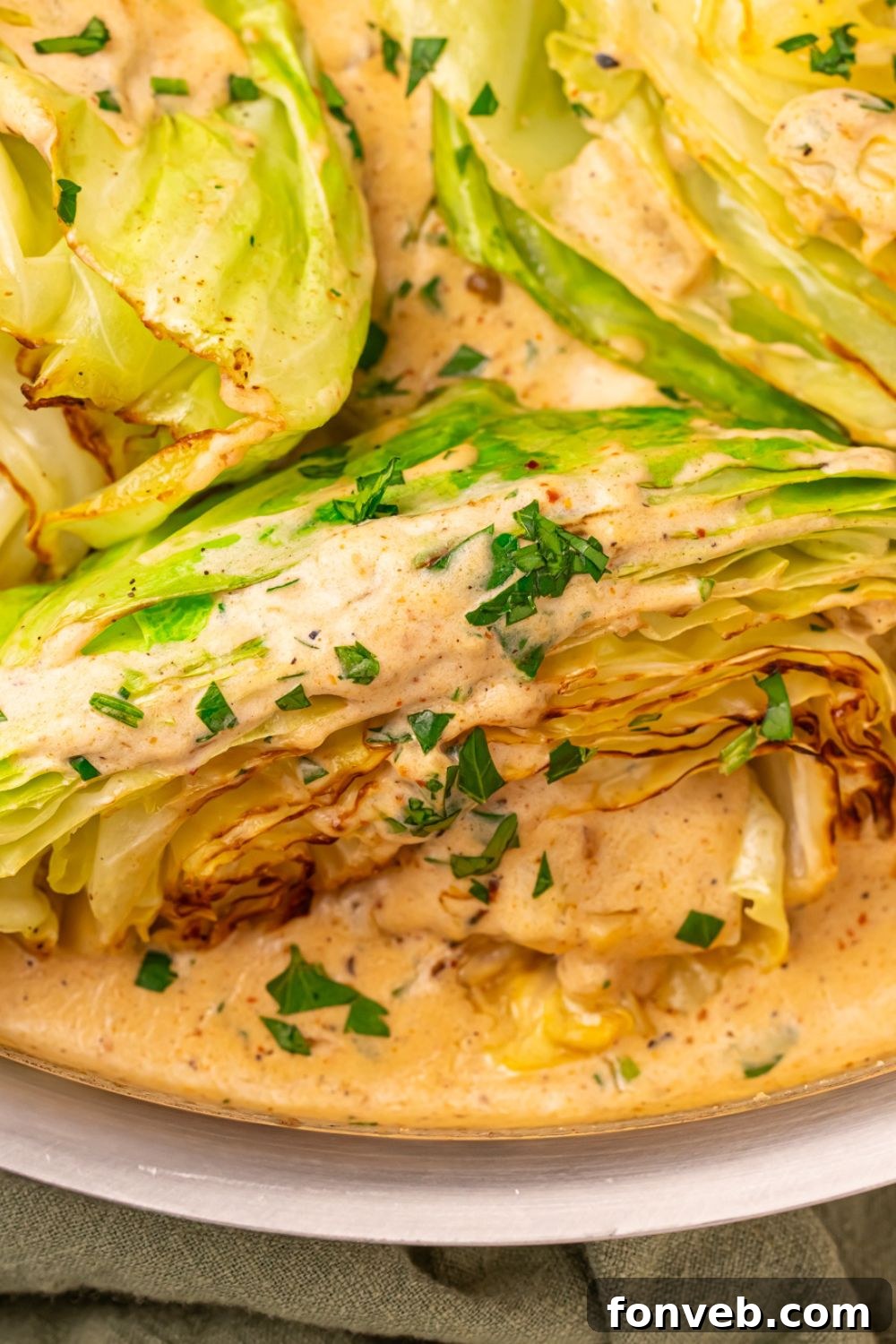 Keto Creamy Garlic Parmesan Cabbage Skillet 5 Creamy Garlic Parmesan Cabbage in a skillet, coated with sauce and garnished with fresh parsley