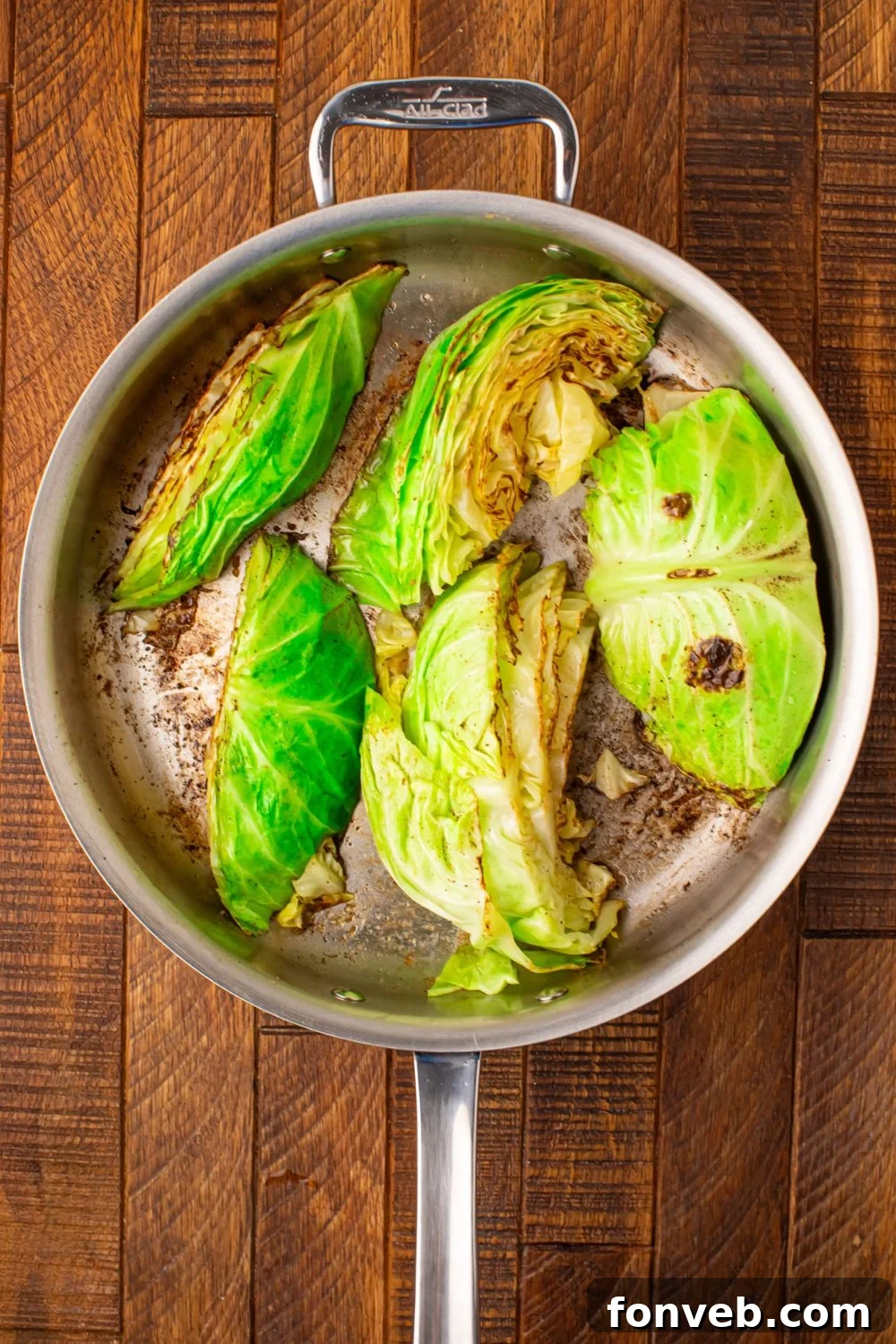 Keto Creamy Garlic Parmesan Cabbage Skillet 8 Cabbage wedges being sautéed in a skillet