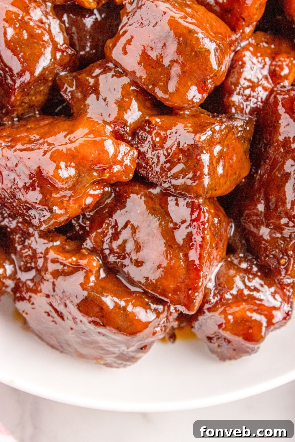 A serving of finished Chuck Roast Burnt Ends, sticky with glaze and perfectly tender, presented on a plate.