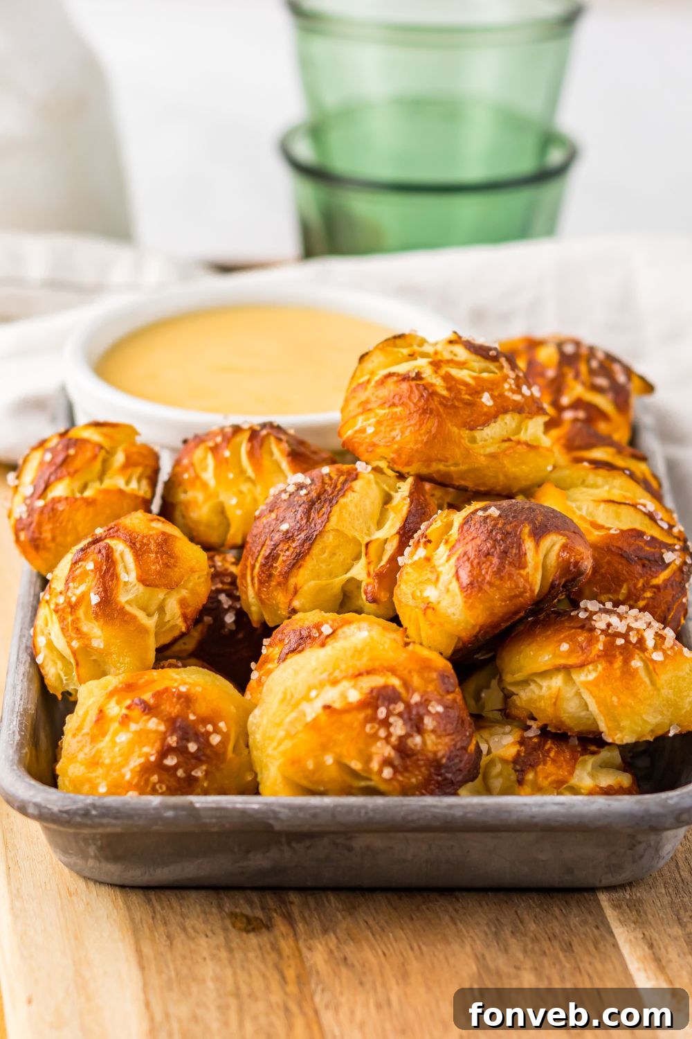 close up of Easy Biscuit Pretzel Bites with Cheese Sauce in a tray sitting on a table 