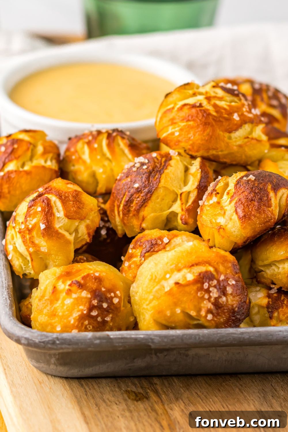 Easy Biscuit Pretzel Bites with Cheese Sauce in a pan with a close up view of it on table 
