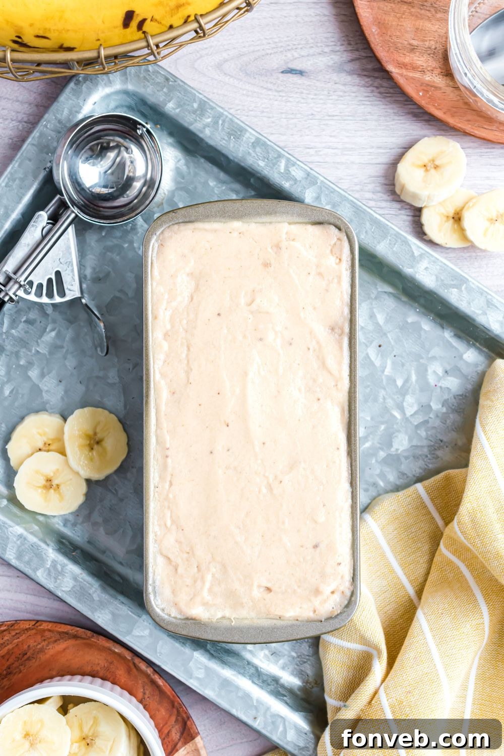 Banana Ice Cream: The One-Ingredient Wonder 13 Banana Ice Cream in a loaf pan with fresh bananas sliced to side and an ice cream scoop to side of pan