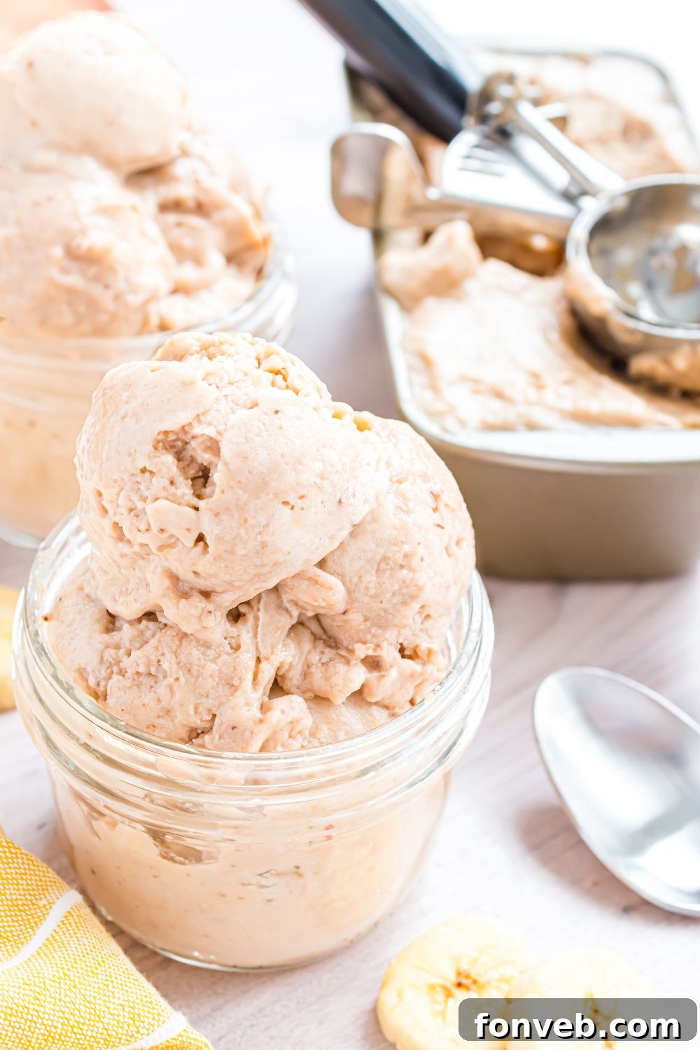 Banana Ice Cream: The One-Ingredient Wonder 20 Banana Ice Cream piled in containers, and then a loaf pan with the rest of ice cream inside and ice cream scoop