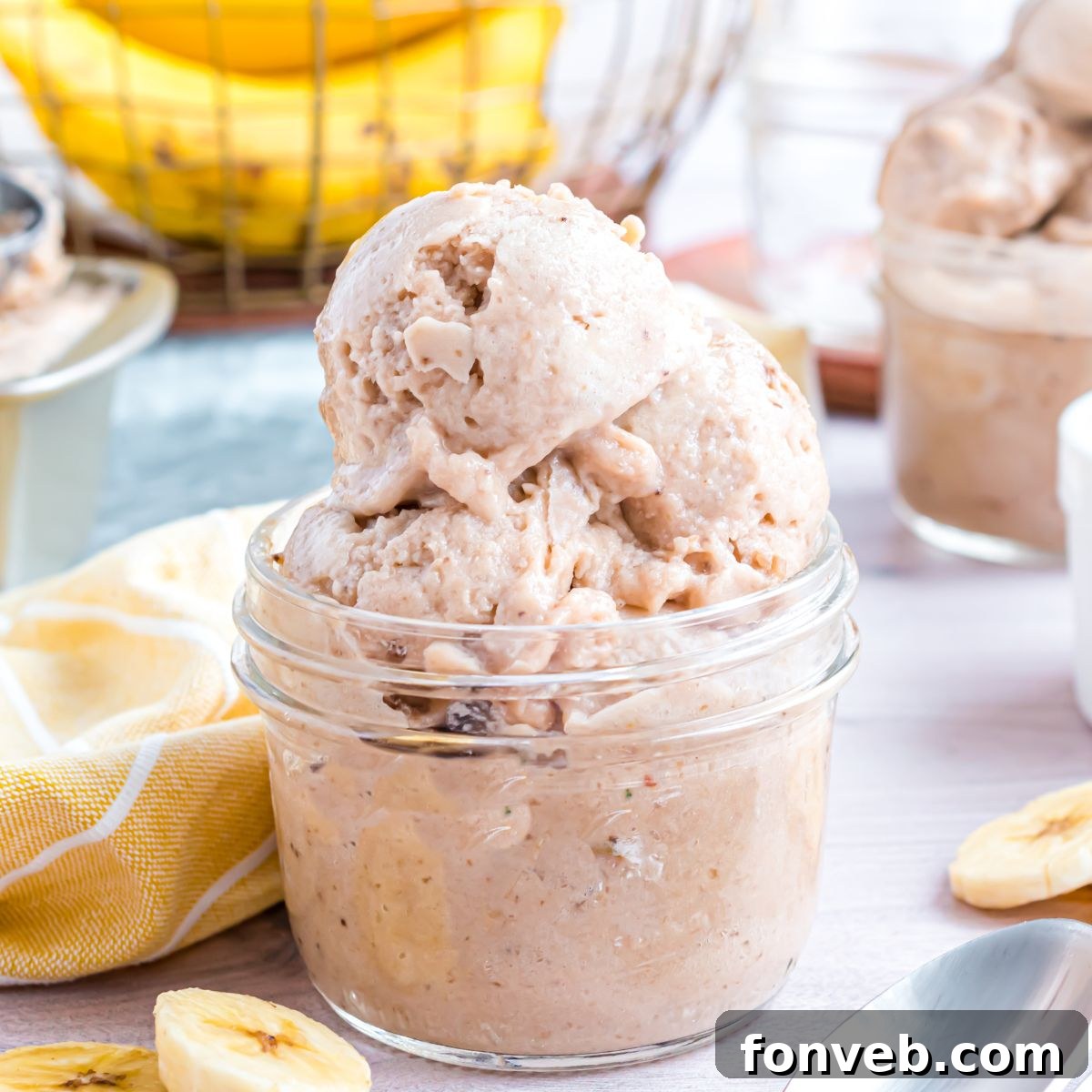 Banana Ice Cream: The One-Ingredient Wonder 3 Banana Ice Cream in a glass bowl on table with slices of bananas around table