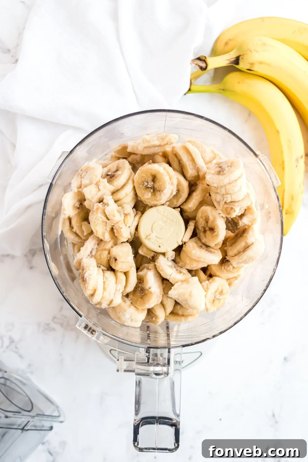 Banana Ice Cream: The One-Ingredient Wonder 8 frozen bananas in a food processor with bananas to side for making Banana Ice Cream