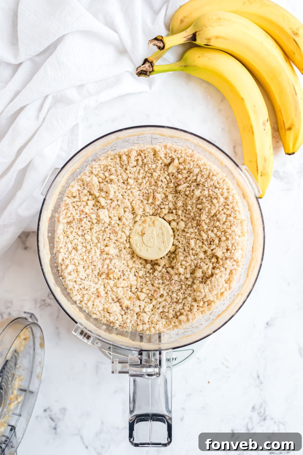 Banana Ice Cream: The One-Ingredient Wonder 9 Banana Ice Cream being made in a food processor with a bundle of bananas to side