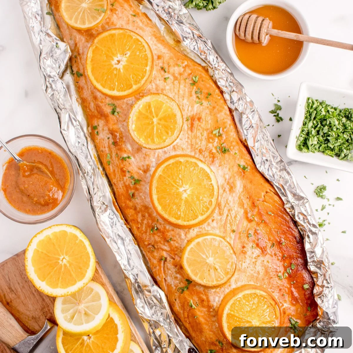 Effortless Honey Mustard Salmon Foil Grill 2 Grilled Honey Mustard Salmon in Foil on table with honey, citrus wedges, etc.