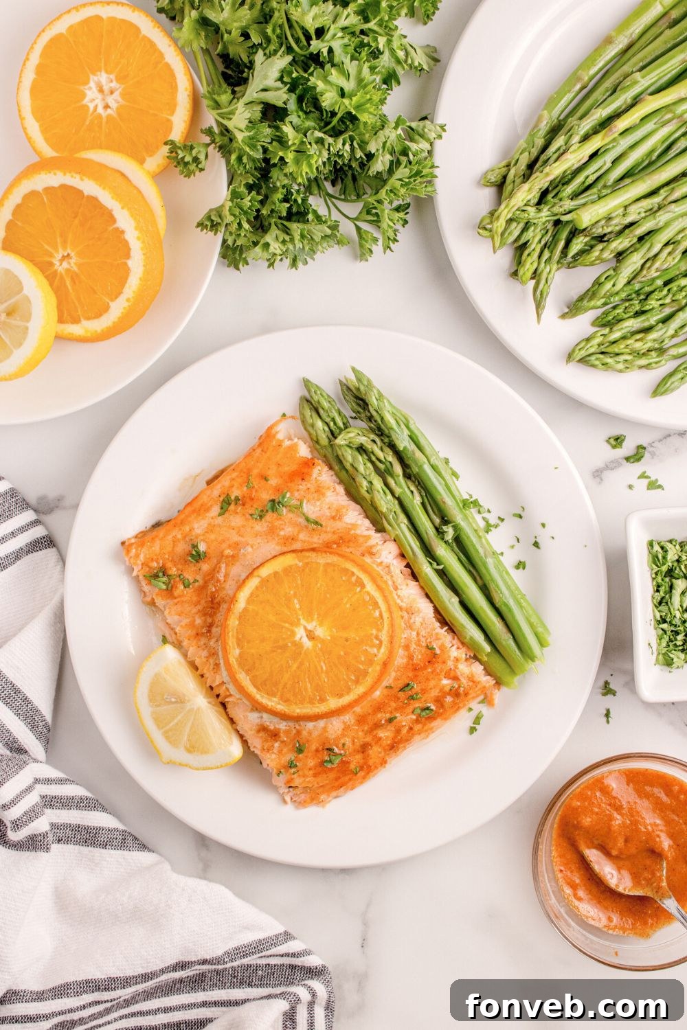 Effortless Honey Mustard Salmon Foil Grill 15 overhead look of table with Grilled Honey Mustard Salmon on plate, asparagus, sliced orange, and more