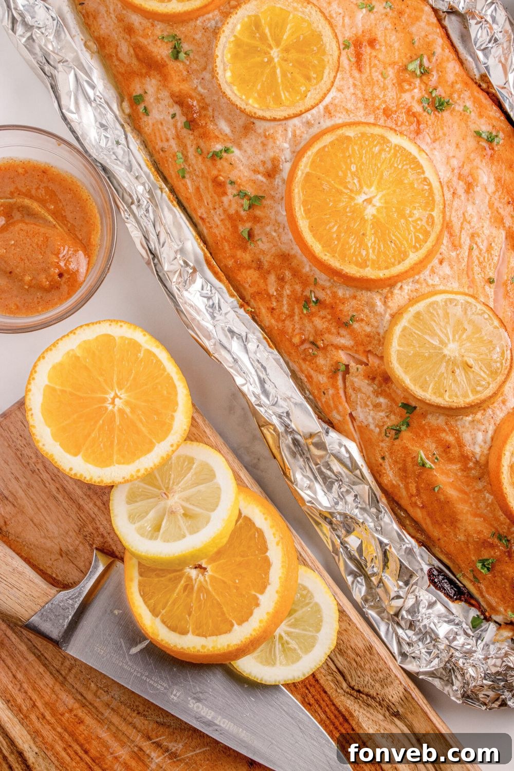 Effortless Honey Mustard Salmon Foil Grill 17 Grilled Honey Mustard Salmon in Foil sitting on table, with more oranges sliced and placed on cutting board to side