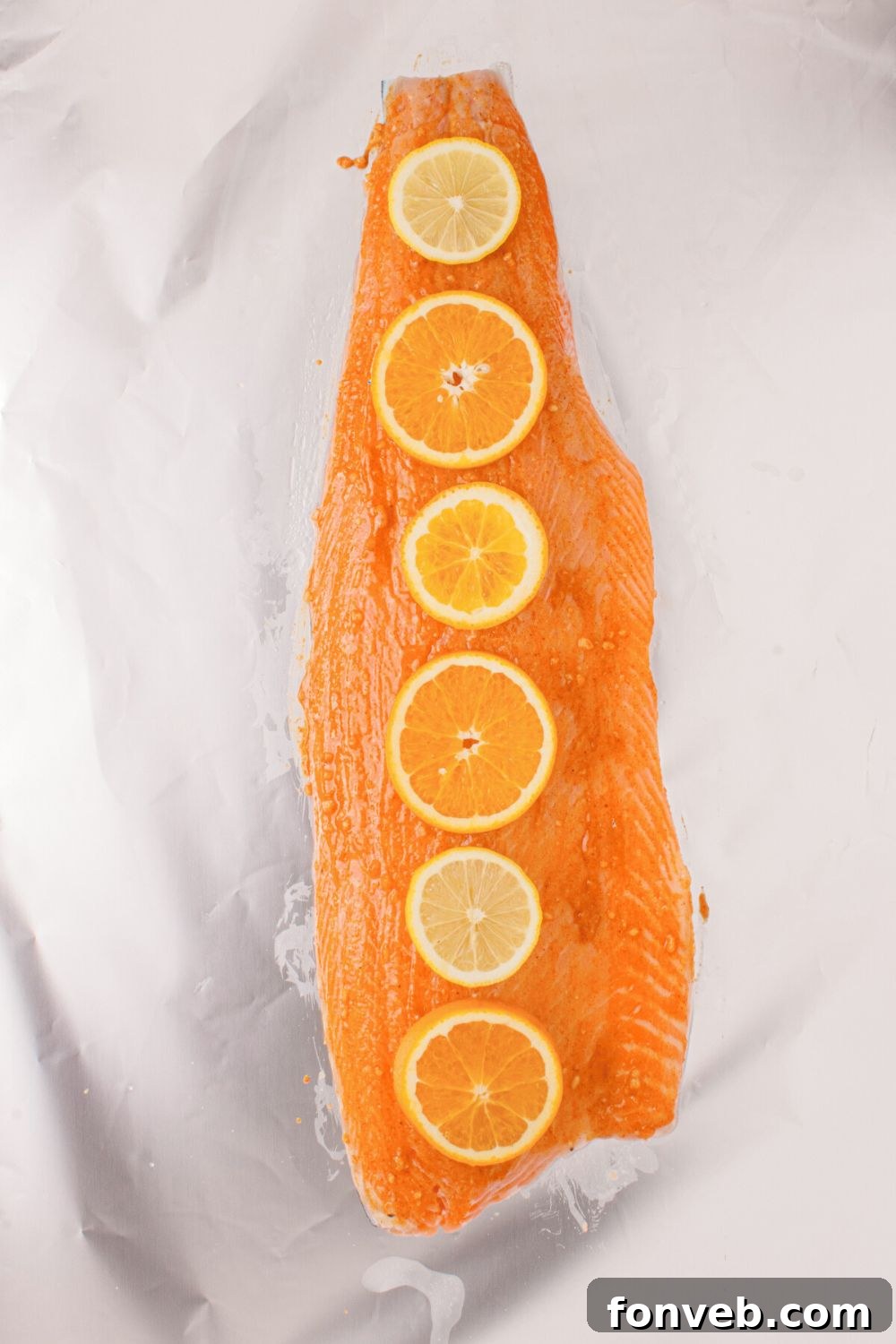 Effortless Honey Mustard Salmon Foil Grill 9 raw salmon with sauce spread on top and orange slices