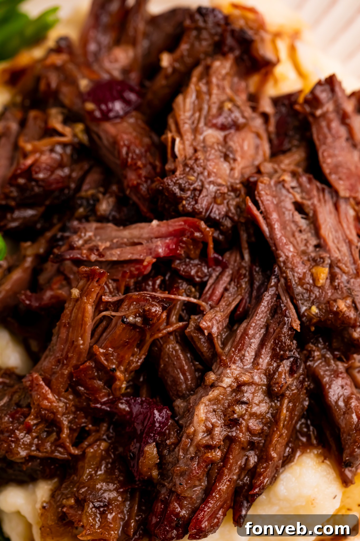 Up close shot of the Cranberry Pot Roast shredded on a white plate 