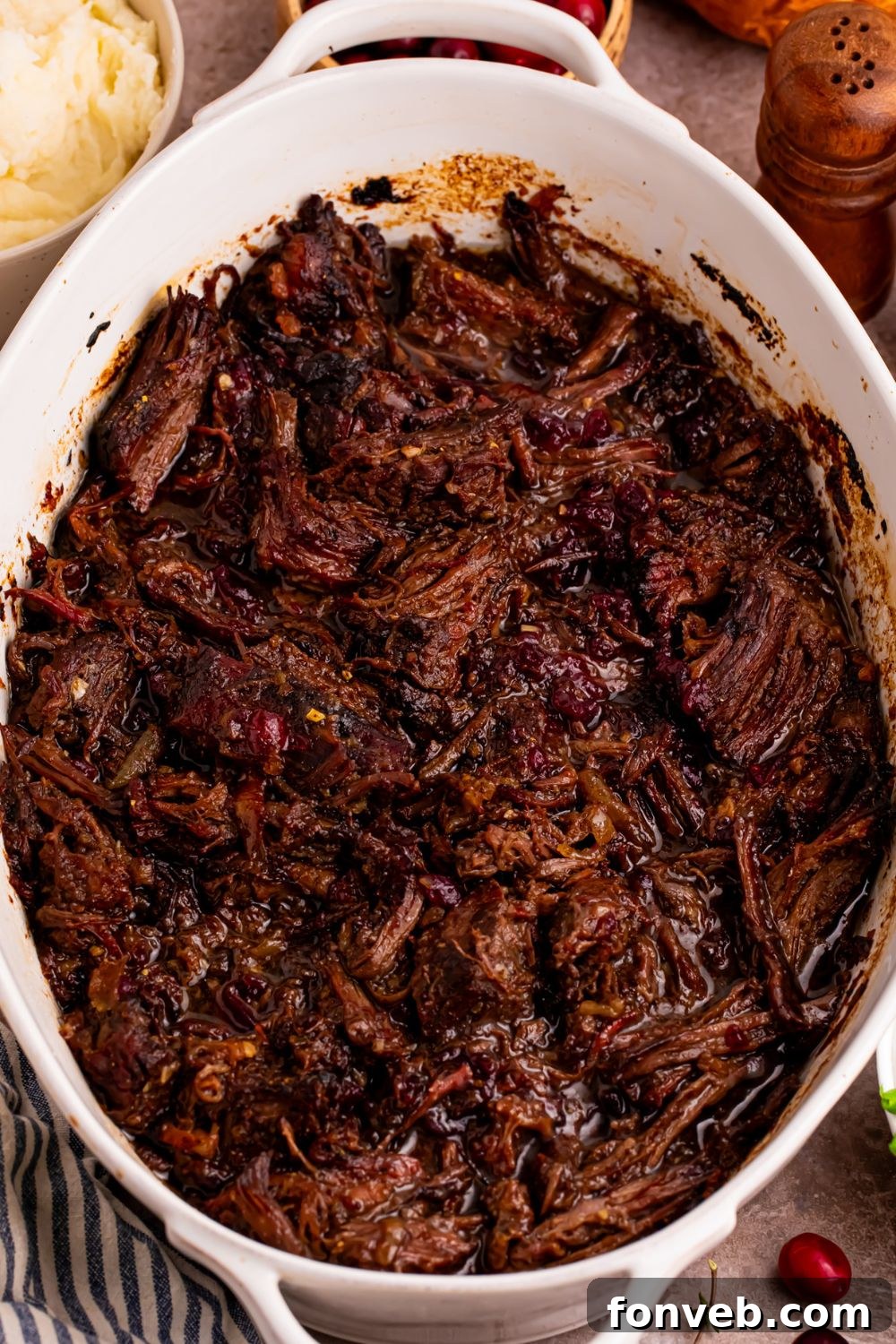 overhead look of casserole dish with shredded Cranberry Pot Roast in it 