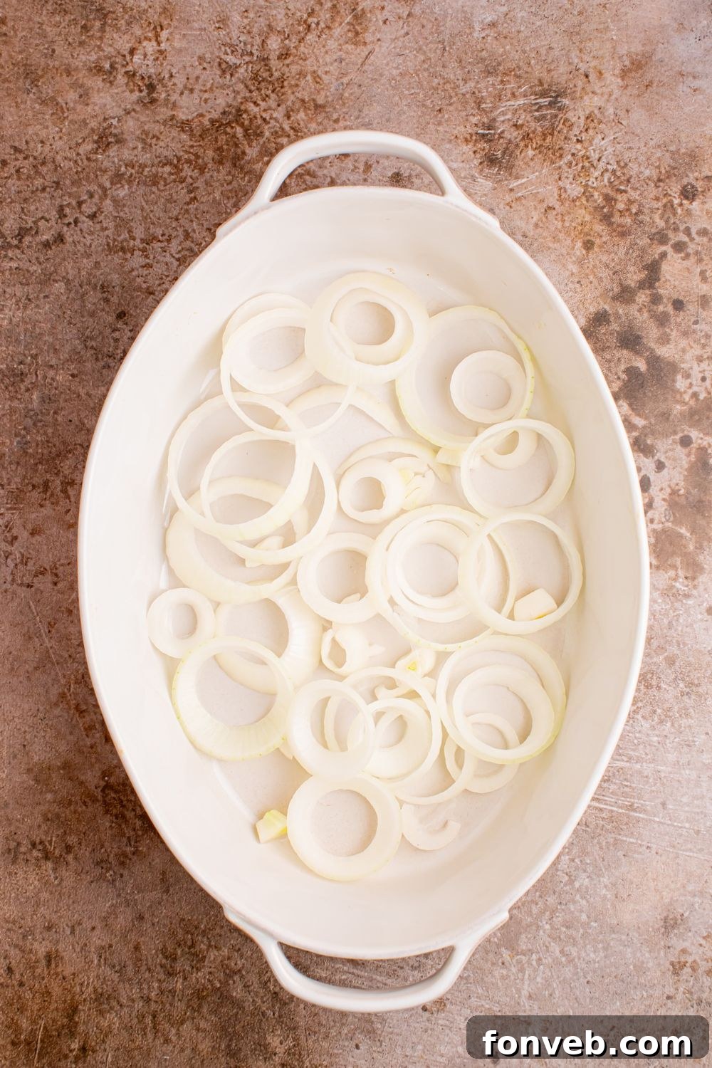 sliced onions in casserole dish on table