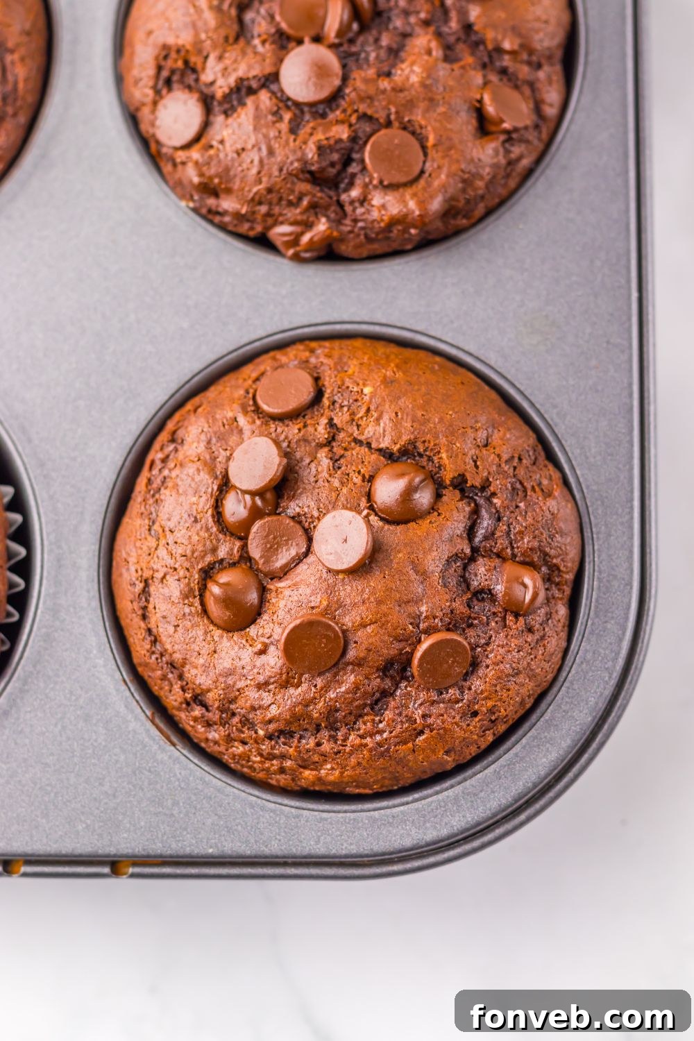 muffin pan with Costco Double Chocolate Muffins in it sitting on table