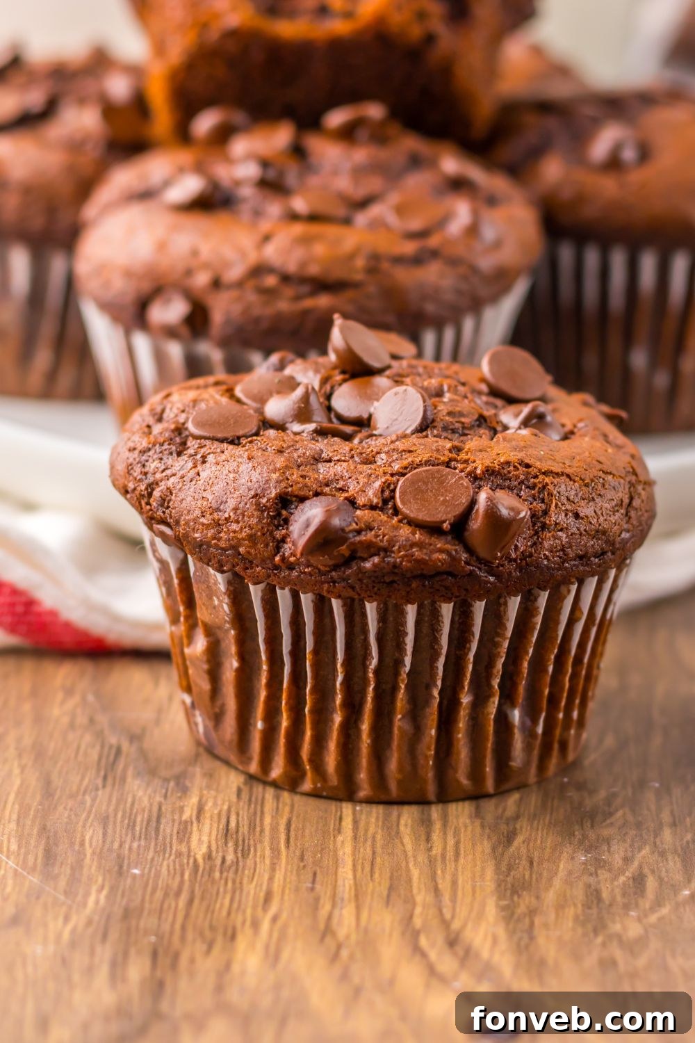close up of Costco Double Chocolate Muffins on table with more in a tray behind it