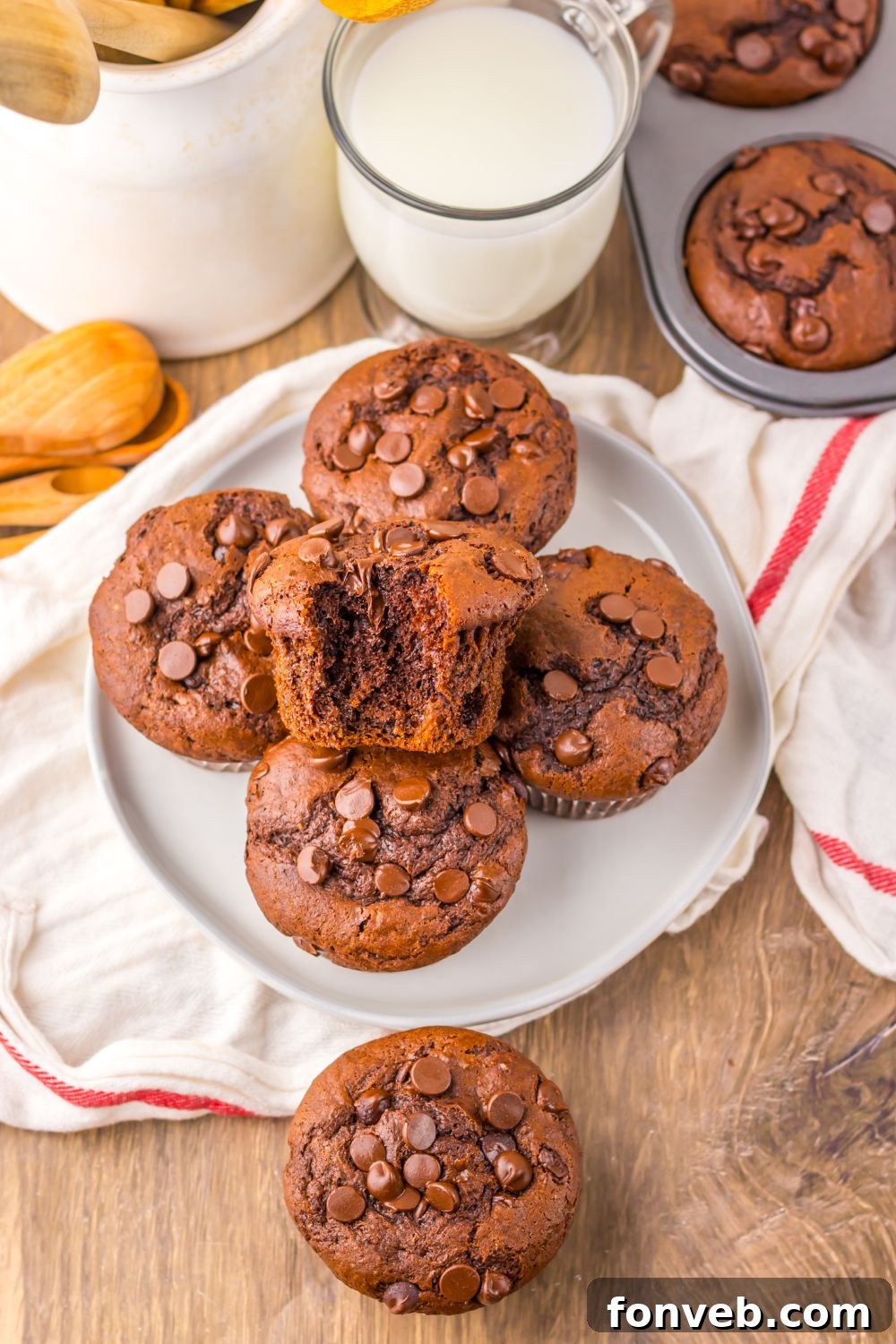 Costco Double Chocolate Muffins around table on a plate, table, and a towel laid out on table