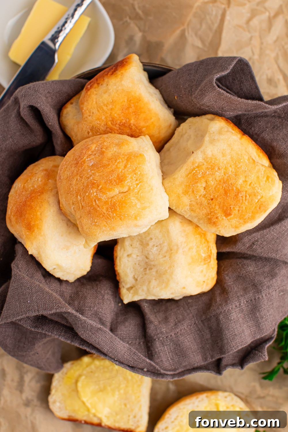 Freshly baked 2-Ingredient Dinner Rolls resting in a charming bread basket, with a side of creamy butter in a small dish, inviting hungry hands to partake.