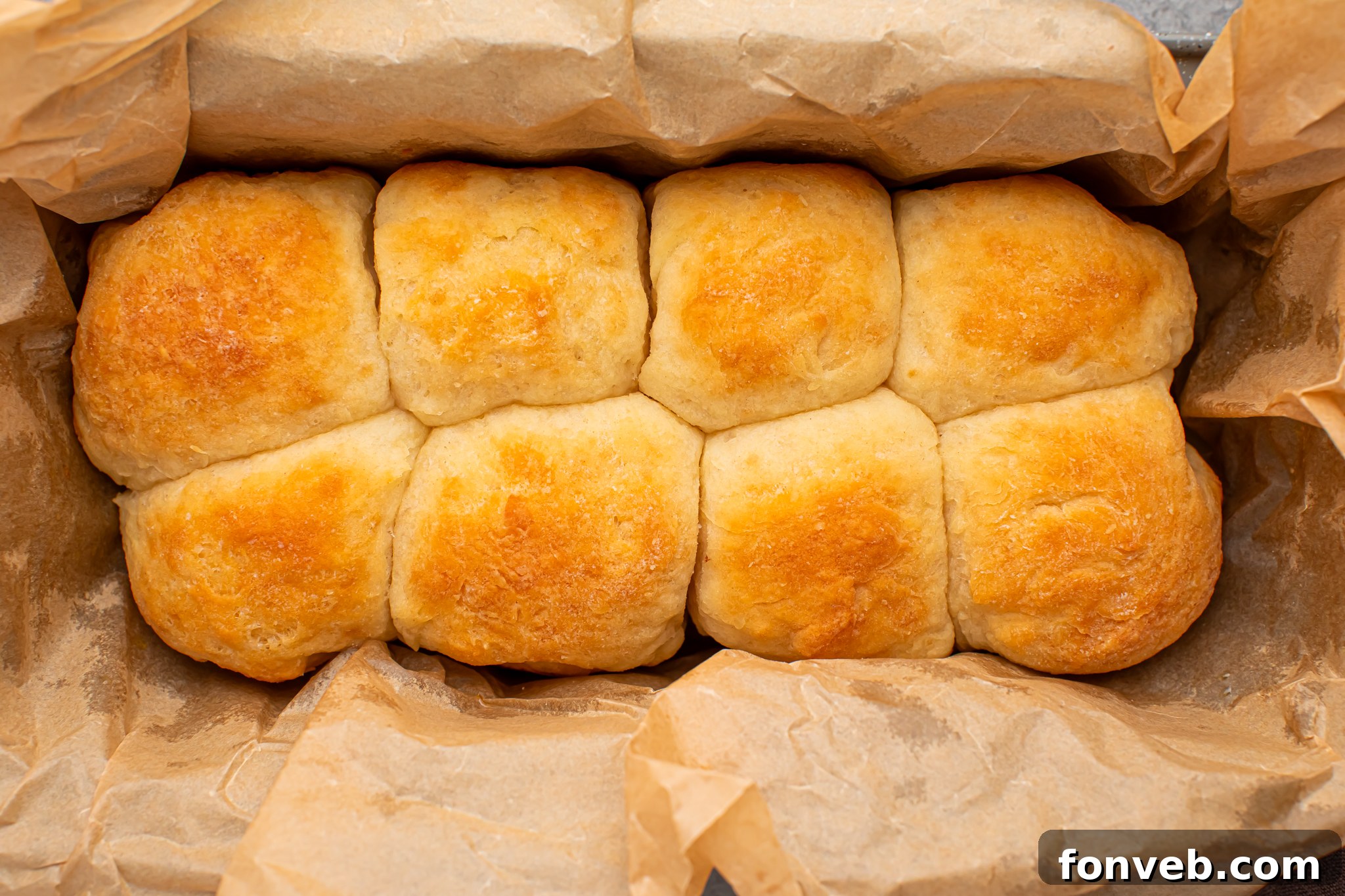 A full baking tray of golden-brown 2-Ingredient Dinner Rolls, with a close-up on their beautifully textured tops, ready to be enjoyed.