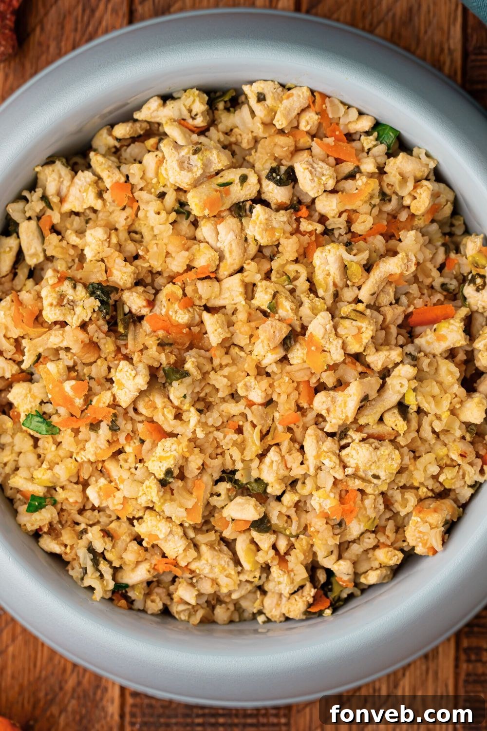 Homemade Turkey and Rice Dog Food with Veggies in a dog bowl on a wooden table 