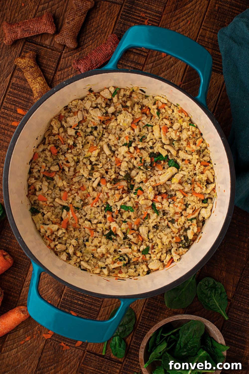 looking down at table with Homemade Turkey and Rice Dog Food with Veggies in a pot, dog treats, and more around the table 