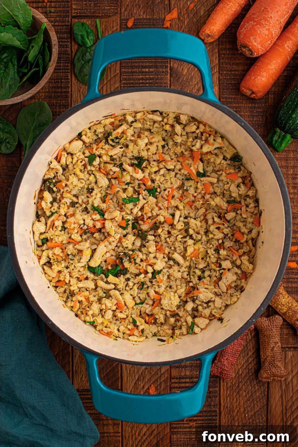 Homemade Turkey and Rice Dog Food with Veggies in a stock pot sitting on table with ingredients around table 