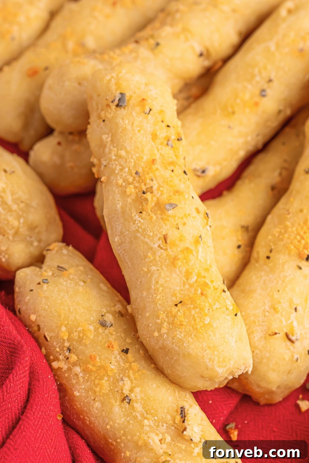 2-Ingredient Buttery Garlic Parmesan Breadsticks 14 2 Ingredient Garlic Parmesan Breadsticks stacked on top of each other on table