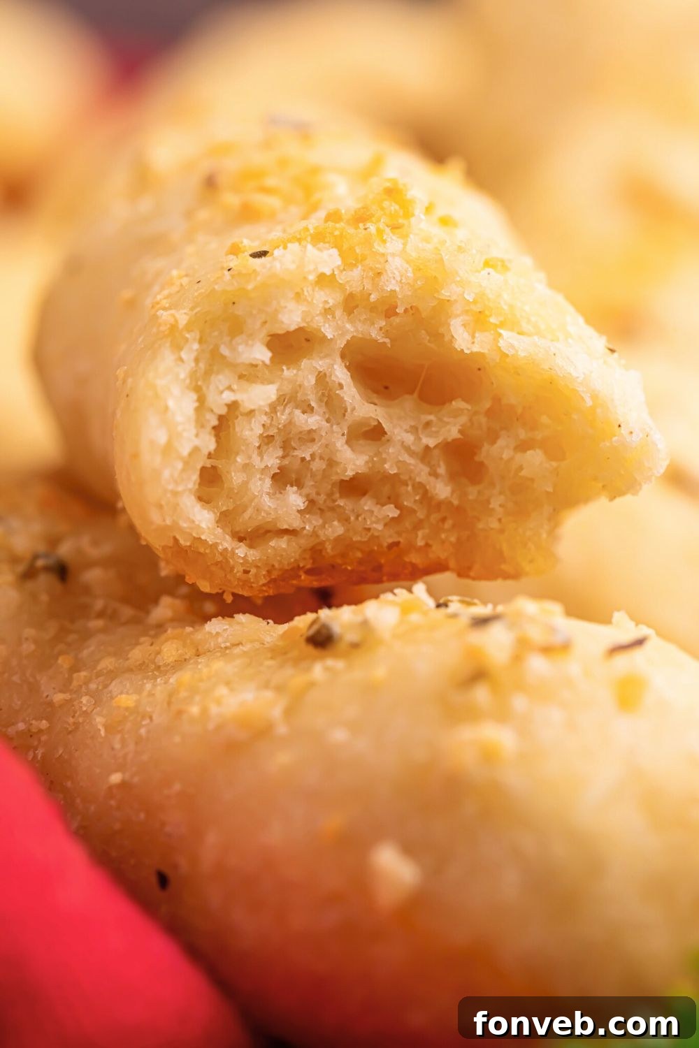 2-Ingredient Buttery Garlic Parmesan Breadsticks 15 2 Ingredient Garlic Parmesan Breadstick on table with a bite taken out of it