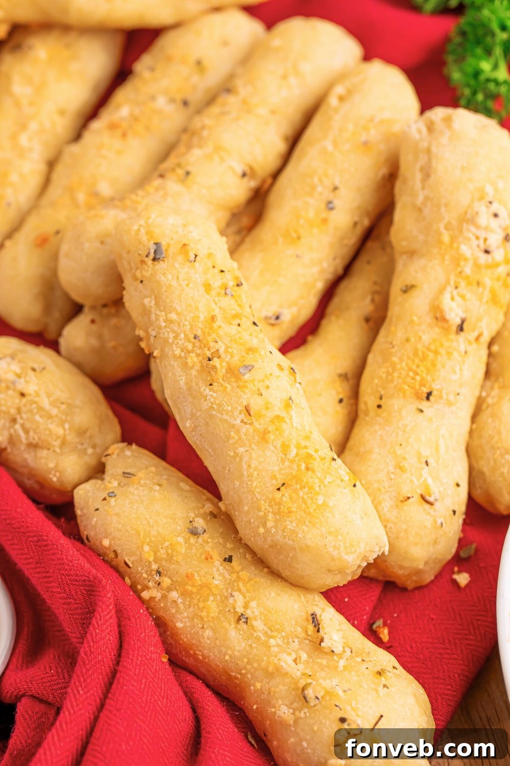 2-Ingredient Buttery Garlic Parmesan Breadsticks 16 view of table full of 2 Ingredient Garlic Parmesan Breadsticks scattered around