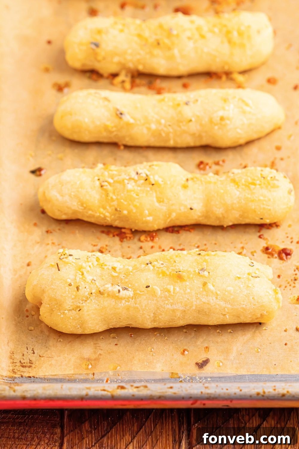 2-Ingredient Buttery Garlic Parmesan Breadsticks 17 baking sheet with 2 Ingredient Garlic Parmesan Breadsticks spread out in a single layer