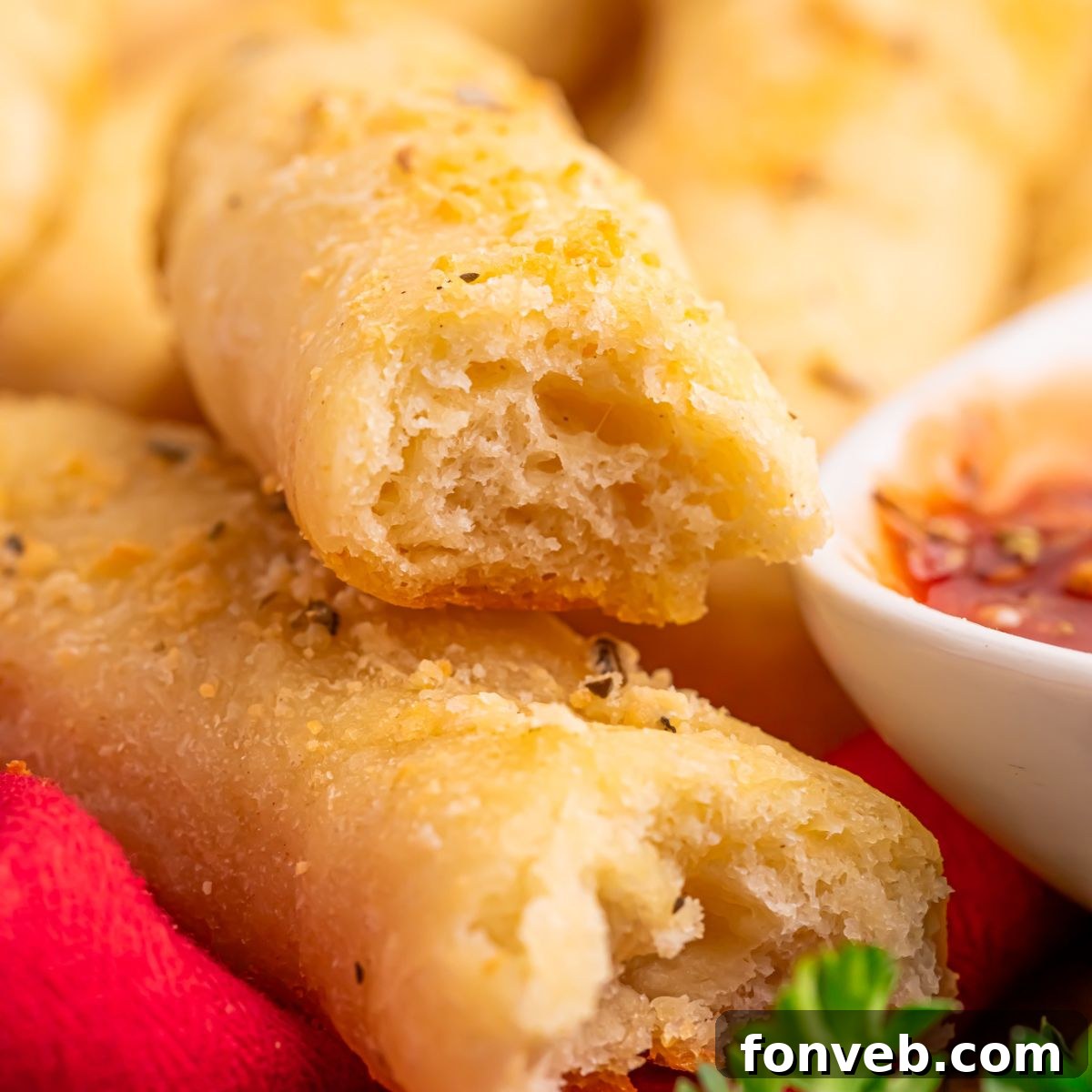 2-Ingredient Buttery Garlic Parmesan Breadsticks 21 2 Ingredient Garlic Parmesan Breadstick on table with one torn in half