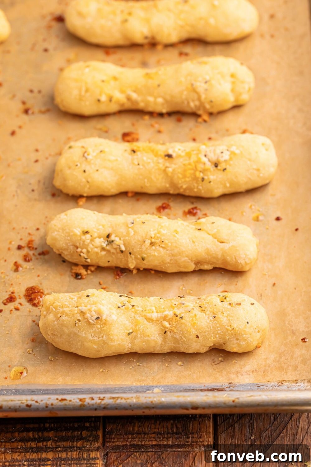 2-Ingredient Buttery Garlic Parmesan Breadsticks 23 line of 2 Ingredient Garlic Parmesan Breadsticks on a baking tray