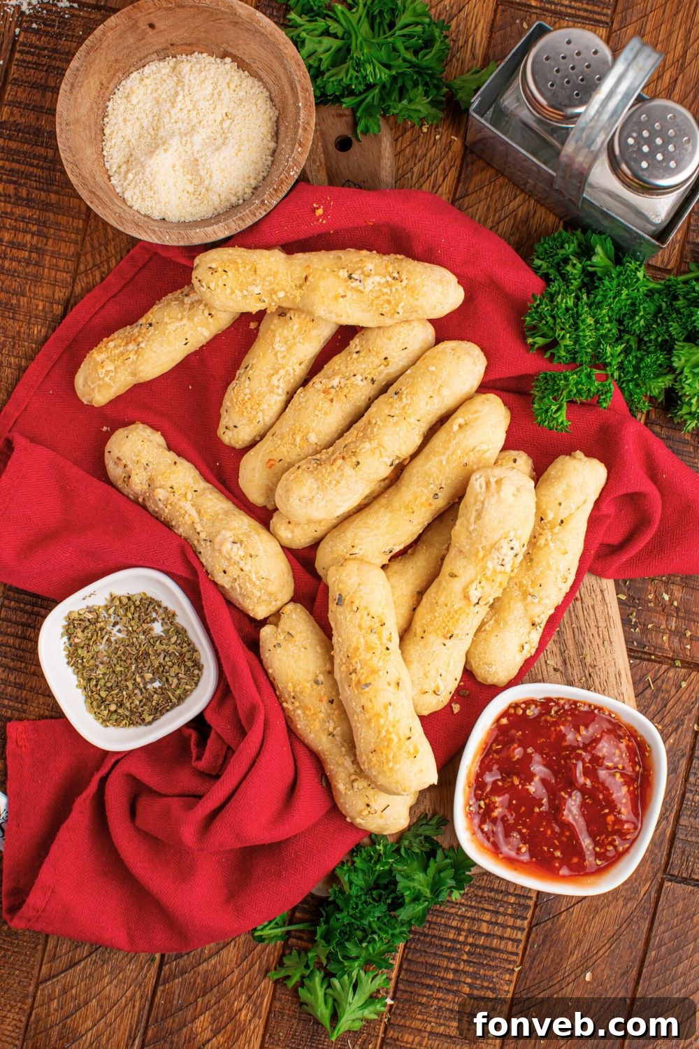 2-Ingredient Buttery Garlic Parmesan Breadsticks 24 overhead look of breadstick with sauce, parmesan cheese, oregano and more