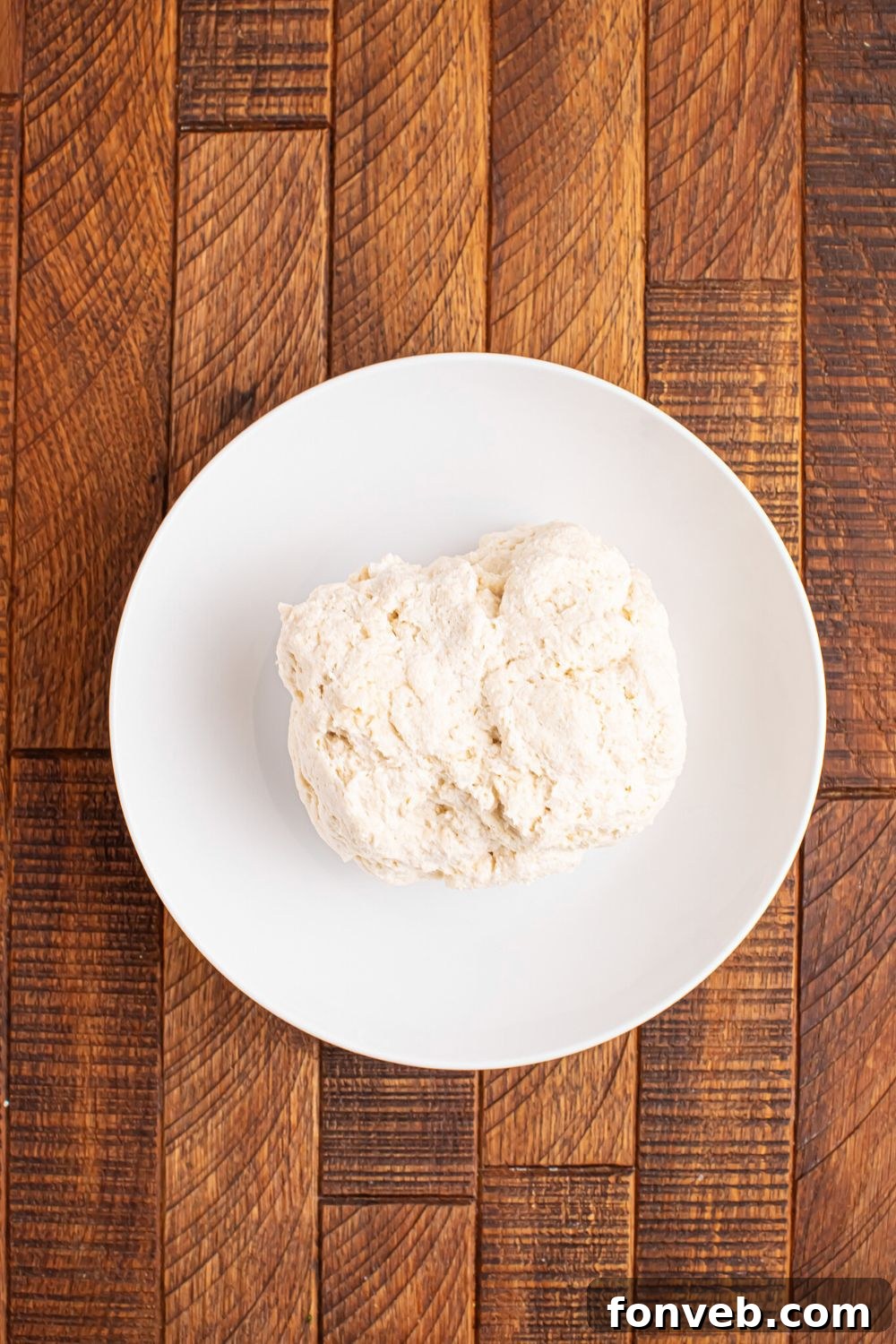 2-Ingredient Buttery Garlic Parmesan Breadsticks 7 plate with a big ball of 2 Ingredient Garlic Parmesan Breadsticks dough on table