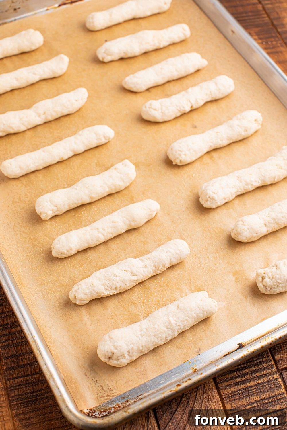 2-Ingredient Buttery Garlic Parmesan Breadsticks 9 tray with 2 Ingredient Garlic Parmesan Breadsticks dough on a baking tray on table