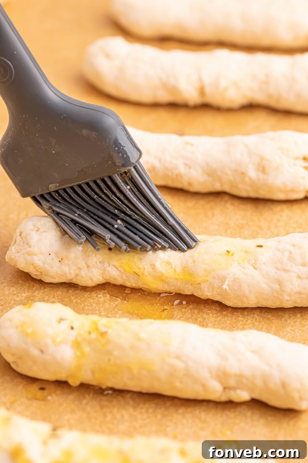 2-Ingredient Buttery Garlic Parmesan Breadsticks 10 brushing raw 2 Ingredient Garlic Parmesan Breadsticks with butter