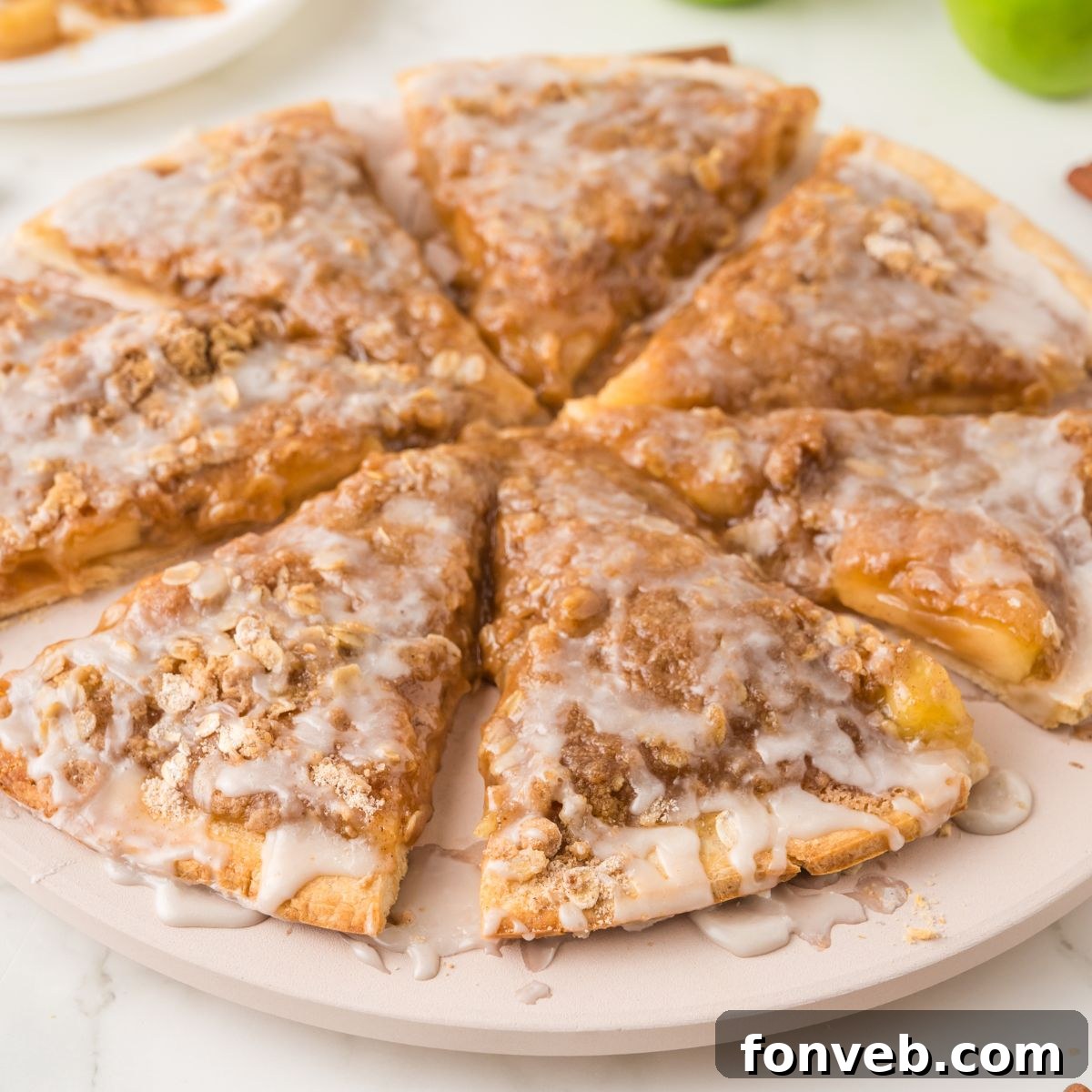 Close-up view of a freshly baked Easy Apple Pie Pizza, sliced into wedges and arranged in a circle on a rustic wooden table, invitingly warm.