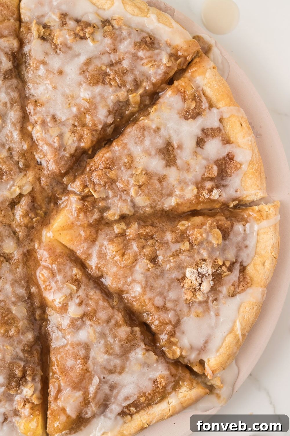 An overhead shot of a perfectly baked Apple Pie Pizza on a wooden table, showcasing its golden crust and delicious toppings.