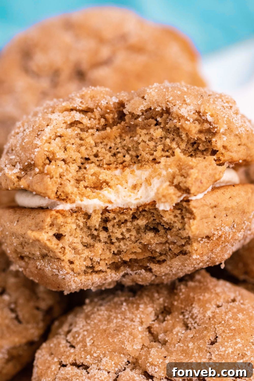 Pillowy Soft Spiced Apple Cider Whoopie Pies 12 Apple Cider Whoopie Pies stacked on table with one with a bite taken out of it to show how fluffy they are