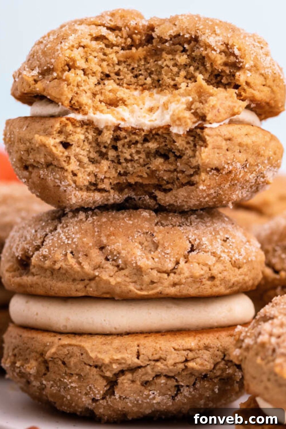 Pillowy Soft Spiced Apple Cider Whoopie Pies 14 stack of Apple Cider Whoopie Pies on table with the top one with a bite taken out of it
