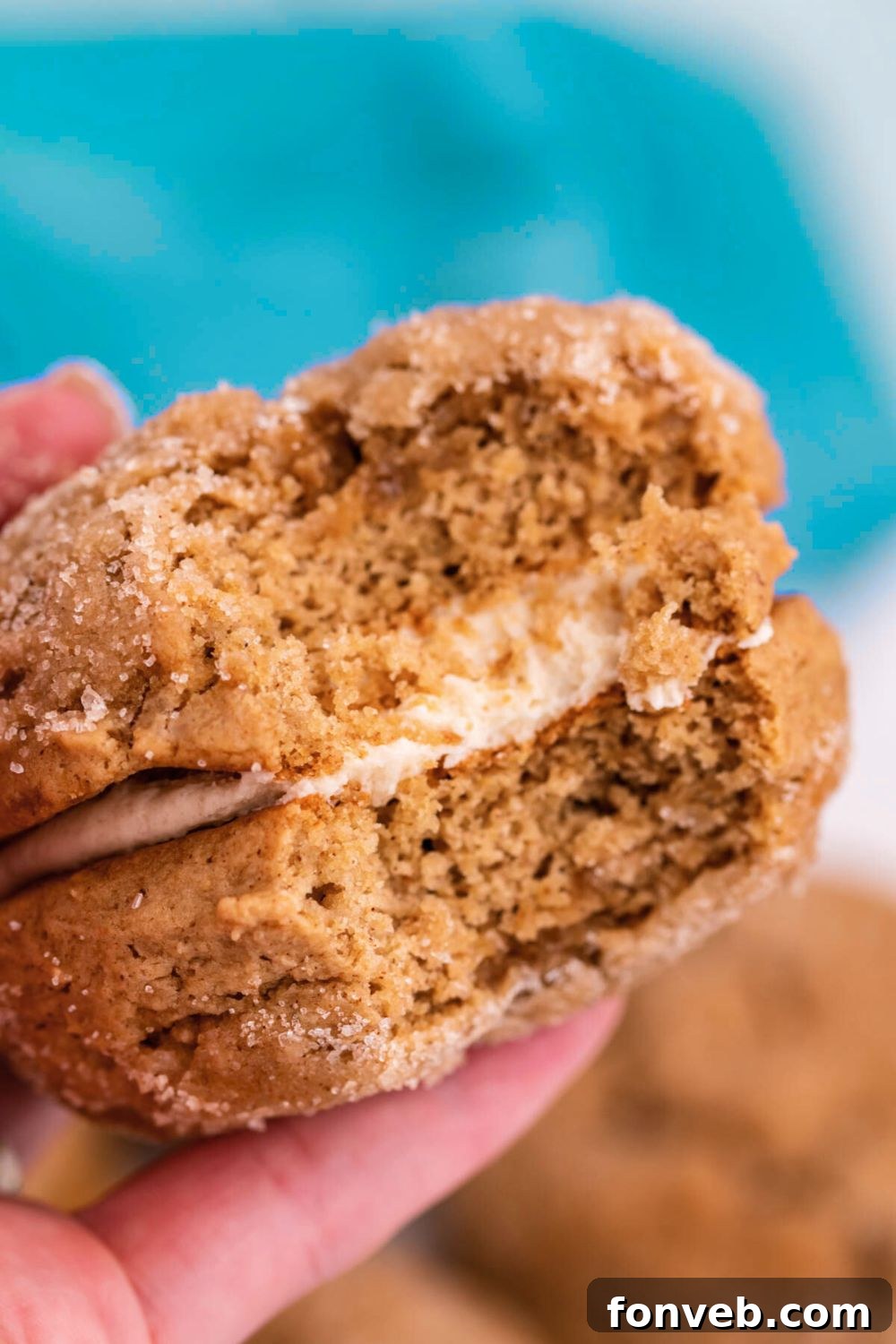 Pillowy Soft Spiced Apple Cider Whoopie Pies 4 bite taken out of Apple Cider Whoopie Pies being held in a hand