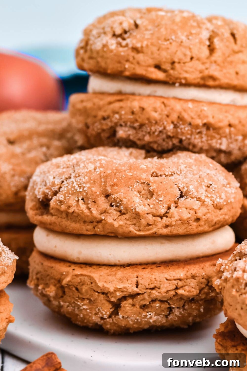 Pillowy Soft Spiced Apple Cider Whoopie Pies 6 Apple Cider Whoopie Pies stacked on the table with apples behind it