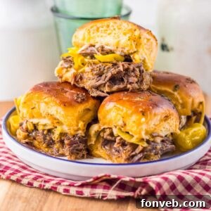 Deliciously Simple Slow Cooker Mississippi Pot Roast Sliders 22 Slow Cooker Mississippi Pot Roast Sliders stacked on a plate sitting on a table