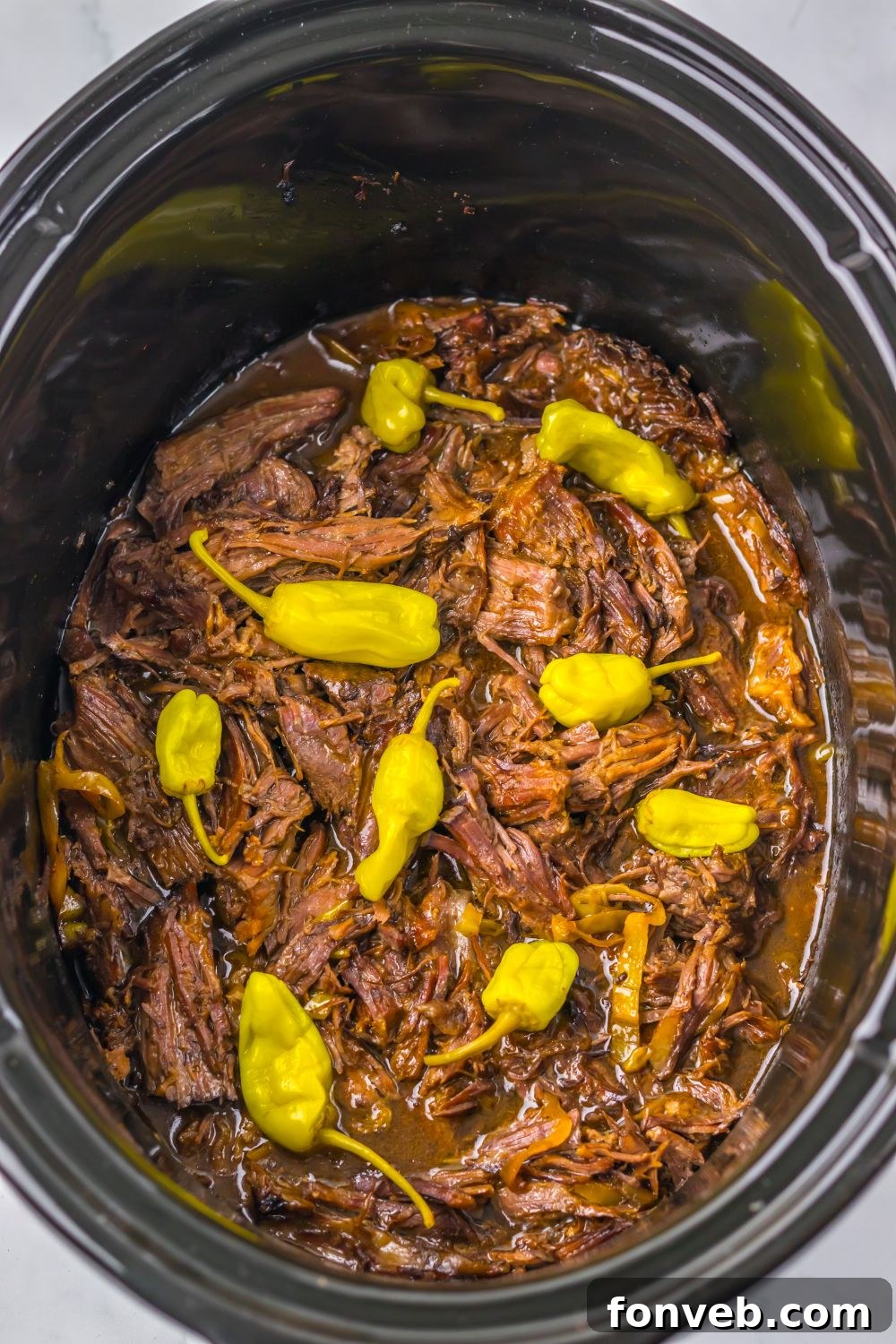 Deliciously Simple Slow Cooker Mississippi Pot Roast Sliders 5 overhead look of Slow Cooker Mississippi Pot Roast in the pan