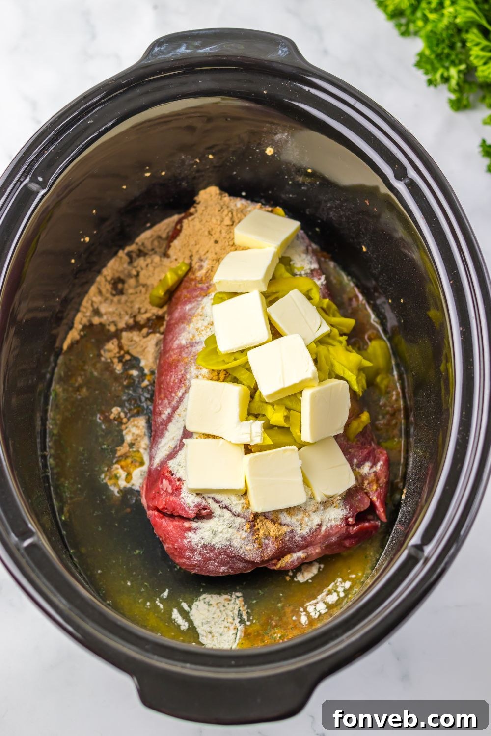 Deliciously Simple Slow Cooker Mississippi Pot Roast Sliders 7 raw pot roast with sauce, butter and peppers