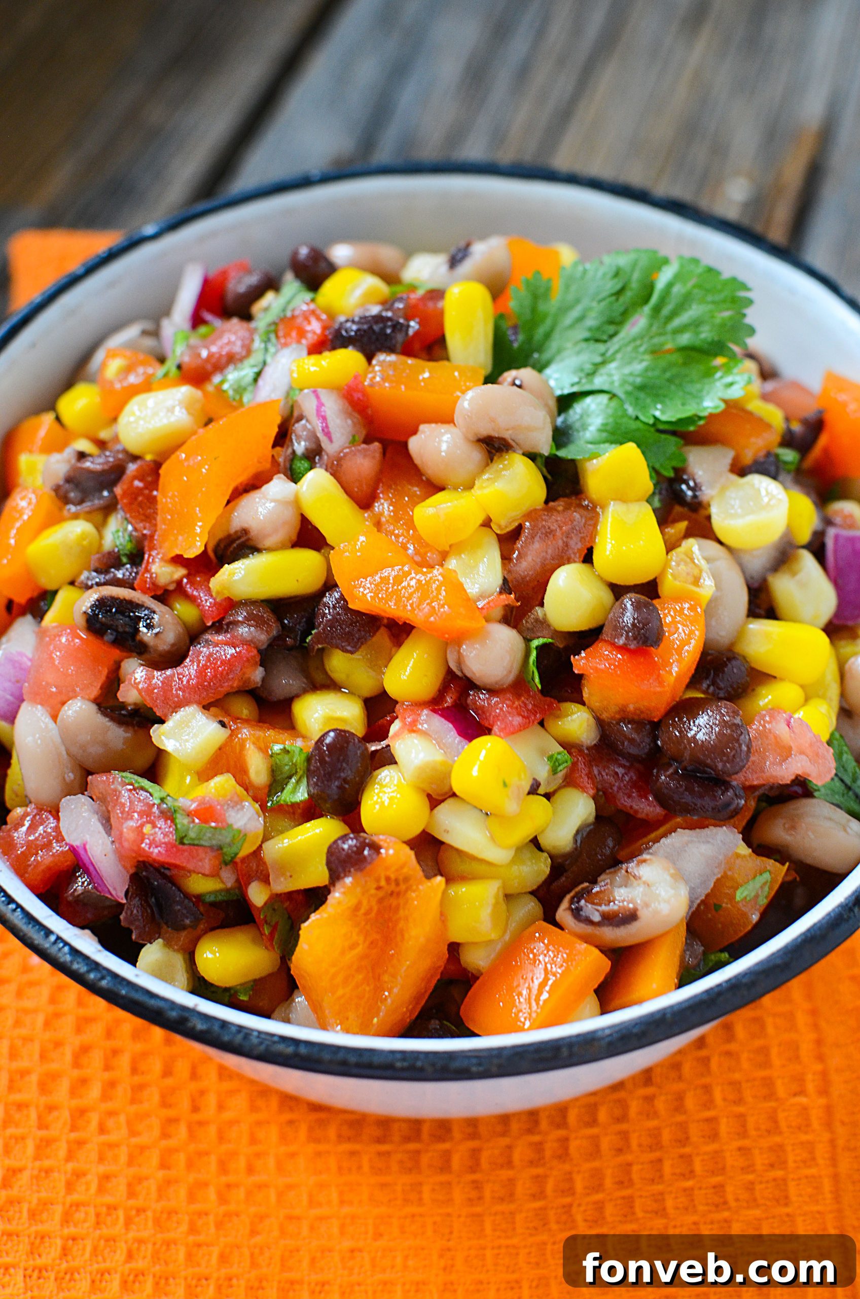 Close-up of the zesty dressing being poured over the Cowboy Caviar ingredients