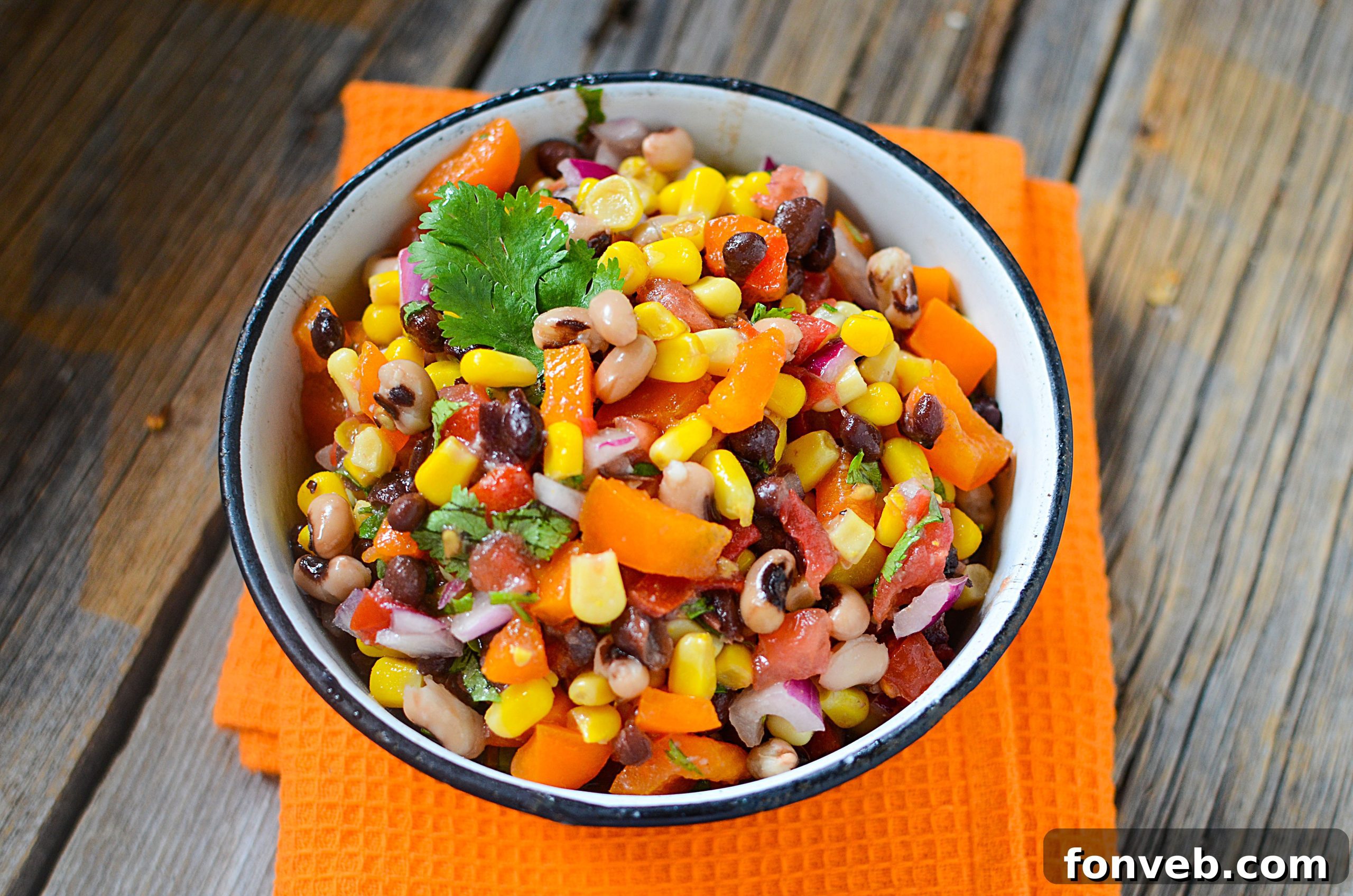 Bowl of mixed Cowboy Caviar with dressing, showcasing its vibrant colors