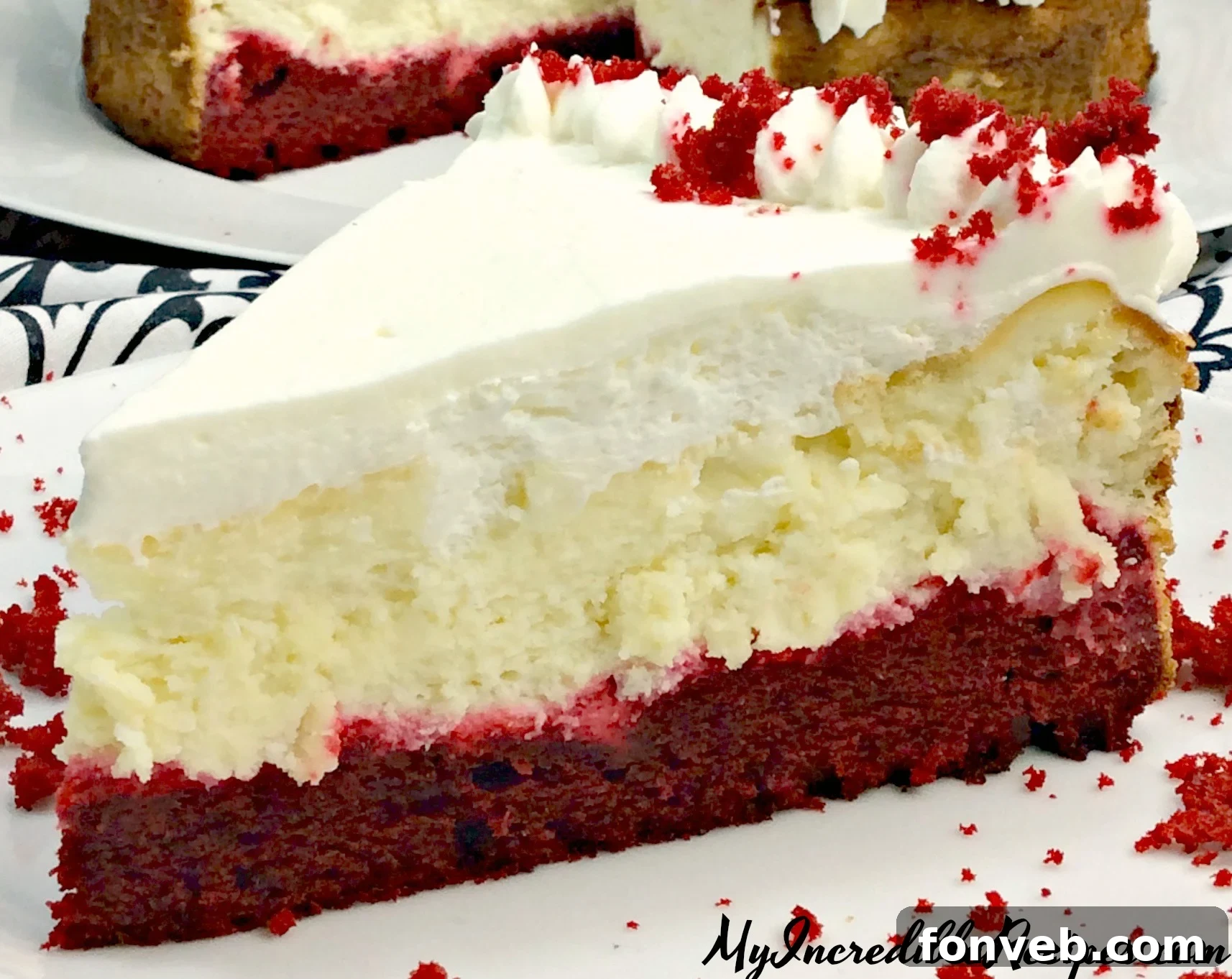 Delicious layered Red Velvet Cheesecake slice with creamy white topping