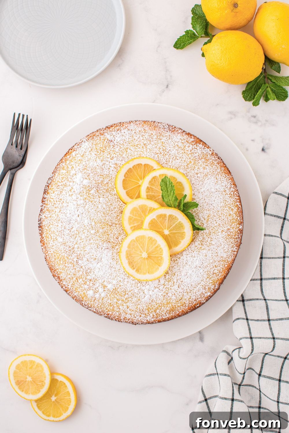 Italian Lemon Ricotta Cake on a table sprinkled with powdered sugar 
